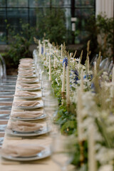 Modern stylish wedding table setting. The wedding decor. The pastel colors flowers bouquet. Natural beautiful wedding decorations. Minimalistic wedding decorations