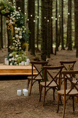 Wedding ceremony decoration in the forest. Twighlight style wedding. Ceremony in the woods. Modern stylish wedding decor