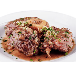 Stewed veal shanks with gremolata on white plate