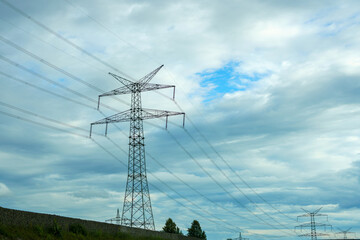 High-voltage pole against the background of the evening cloudy sky.