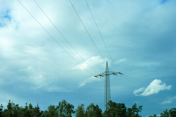 High-voltage pole against the background of the evening cloudy sky.