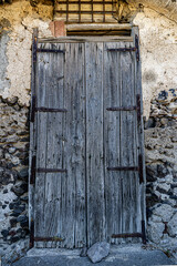 Close up shot of a wooden door in a small village in the Aeolia islands, Sicily. Weathered wood that talks about ancient history.