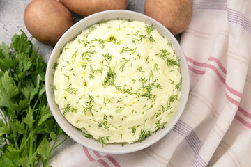 Mashed potatoes in white bowl on grey concrete background. Healthy food