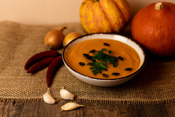 A bowl of pumpkin soup on the table. Autumn vegetables. Homemade food