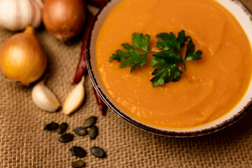 A bowl of pumpkin soup on the table. Autumn vegetables. Homemade food