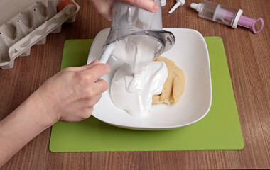 Dough preparation process. Woman mix in bowl powdered sugar, almond flour and beaten egg white using silicone spatula. Baking macarons at home. Close-up of hands.