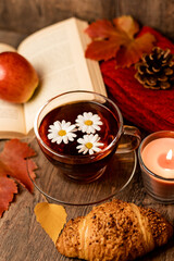 Autumn composition, tea, pumpkins, candle on the table. Autumn comfort at home