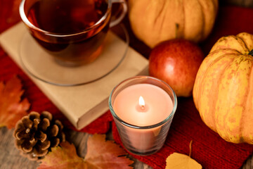 Autumn composition, tea, pumpkins, candle on the table. Autumn comfort at home