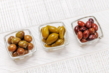 An assortment of various olives presented in a bowl, showcasing different colors, textures, and flavors