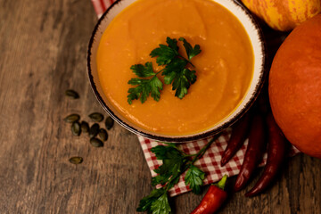 A bowl of pumpkin soup on the table. Autumn vegetables. Homemade food