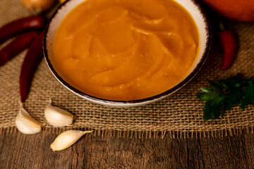 A bowl of pumpkin soup on the table. Autumn vegetables. Homemade food