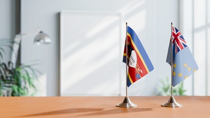 FLAGS OF ESWATINI AND TUVALU ON TABLE