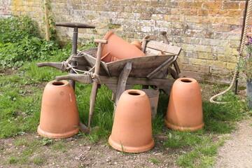 Obraz premium A Wheelbarrow Display with Tools and Terracotta Pots.