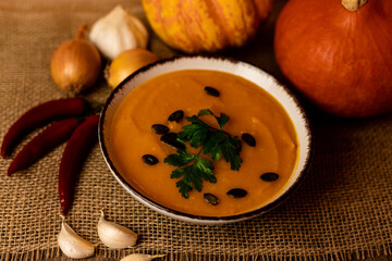 A bowl of pumpkin soup on the table. Autumn vegetables. Homemade food