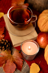 Autumn composition, tea, pumpkins, candle on the table. Autumn comfort at home