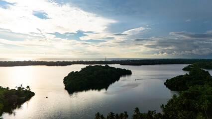 Dusk view of Sri Lanka's tranquil waters. A serene landscape featuring calm waters and lush greenery in Sri Lanka, showcasing the beauty of nature during dusk hours.