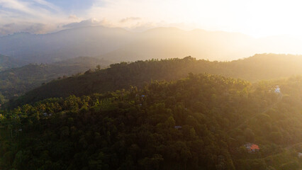 Serene sunset over lush hills in Sri Lanka. A beautiful sunset casts a warm glow over the rolling hills and greenery in Sri Lanka, highlighting the natural beauty of the landscape.
