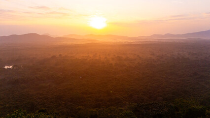 Sunrise over Sri Lanka's lush landscape. A breathtaking sunrise illuminates the green hills and valleys of Sri Lanka, casting warm hues across the tranquil morning sky.