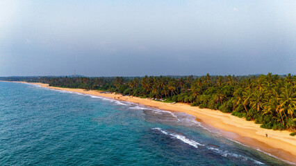 Sunset over Sri Lanka's lush coastline. Golden sands meet clear waves along the serene Sri Lankan...