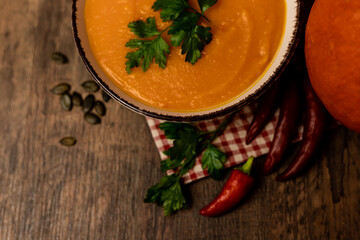 A bowl of pumpkin soup on the table. Autumn vegetables. Homemade food
