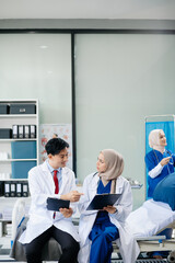 Medical professionals in modern hospital collaborating on patient care, research, and diagnosis. Doctors and nurses in hijabs discussing treatment plans, lab