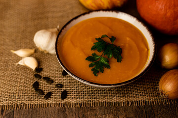 A bowl of pumpkin soup on the table. Autumn vegetables. Homemade food