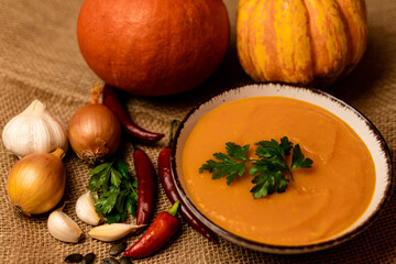 A bowl of pumpkin soup on the table. Autumn vegetables. Homemade food
