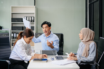 Furious team Asian businesspeople arguing strongly after making a mistake at work in office