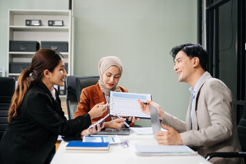 Office colleagues have a casual discussion. During a meeting in a conference room, a group of business teem