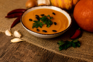 A bowl of pumpkin soup on the table. Autumn vegetables. Homemade food