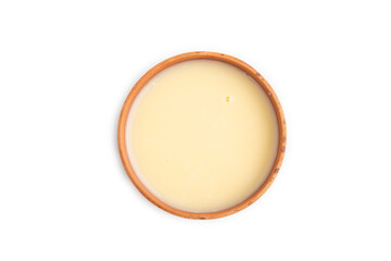 Organic non dairy banana and soy milk in clay cup isolated on white, top view, close up.