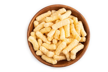 Corn flakes sticks with caramel in wooden bowl isolated on white, top view, close up.