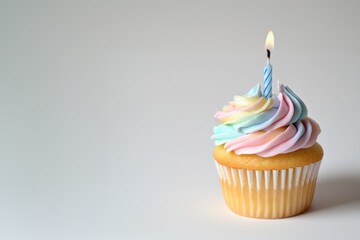 A delightful vanilla cupcake topped with pastel frosting and a lit candle for celebration