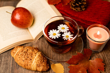 Autumn composition, tea, pumpkins, candle on the table. Autumn comfort at home