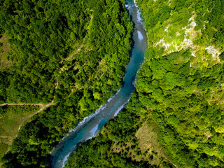 Mountain river flowing through the forest. Aerial view