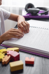 : Children's hands on a Braille book – inclusion, blindness, disability.