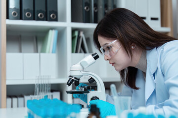 Scientist Conducting Research in Modern Laboratory with Microscope and Protective Gear