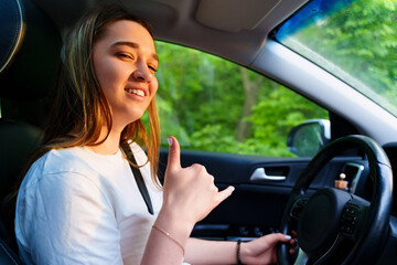 A young girl is driving a car. an inexperienced driver. 