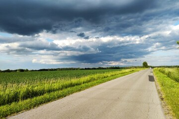 Wiejski krajobraz i droga w momencie nadchodzącej burzy