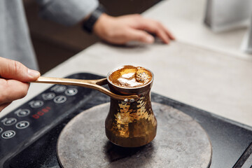 Brewing of Turkish Coffee in Traditional Heavy on Modern Stovetop