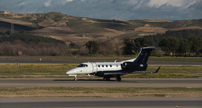 Madrid, Spain - February 02, 2024: Luxury Embraer Phenom 300 business jet aircraft of Atmospherica Aviation Airlines taxing in Madrid-Barajas Airport during sunny day