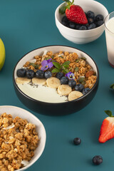 A healthy nutritious breakfast of natural Greek yoghurts, granola and fresh berries.