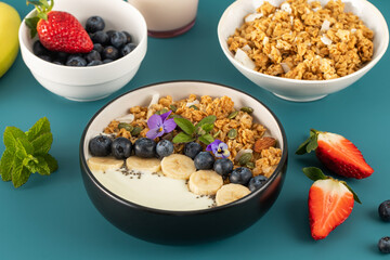 A healthy nutritious breakfast of natural Greek yoghurts, granola and fresh berries.