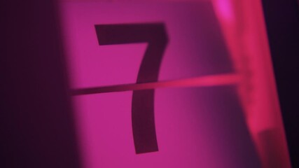 31 days in a month on a flip clock calendar in pink light