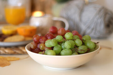 Pumpkins, various food and drinks, fall decorations, books and candles on the table. Fall hygge at home. Selective focus.