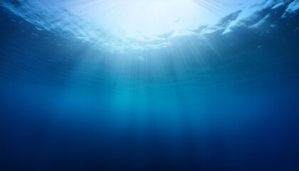 abstract image of tropical underwater dark blue deep ocean wide nature background with rays of sunlight and blue sky in background