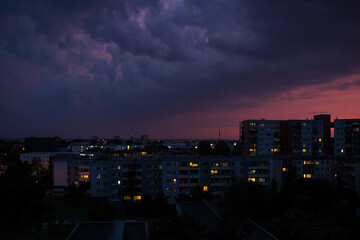 night view of the city. The sky over the city before rain and thunderstorm. The sunset illuminates the dark clouds.