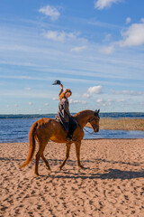 Stylish professional female jockey standing near horse. Friendship with horse. 