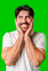 Naklejka premium Young man with a beard smiles and poses in front of a bright green background