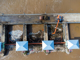Aerial view of the dam's floodgates with rapid flow of water in the rainy season. Dam water...